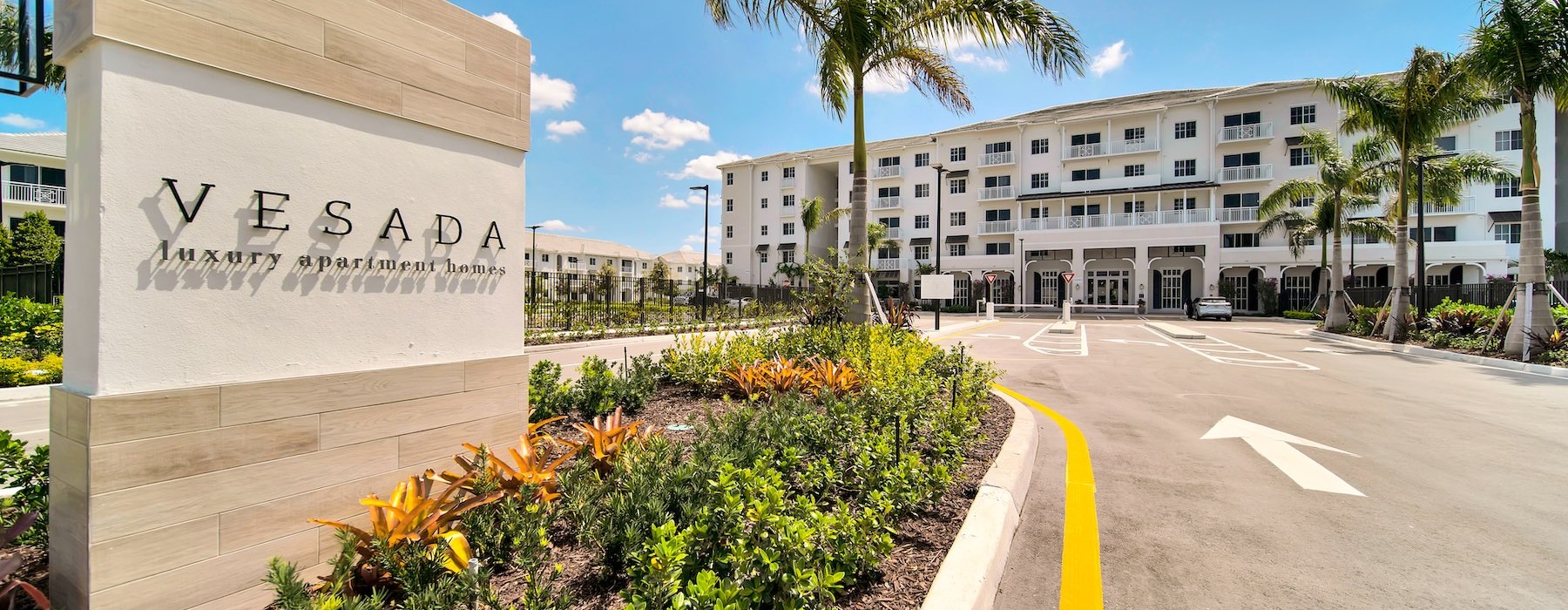 Settle into comfort at Vesada a road with palm trees and a building on the side