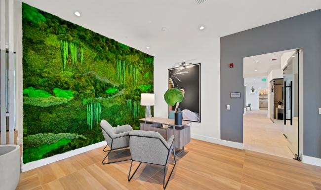 a room with a glass wall and a table with chairs and a plant